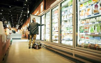 Shot of a mature man shopping in the cold produce section of a supermarket