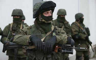 Perevalne, UKRAINE - MARCH 02:  Soldiers who were among several hundred that took up positions around a Ukrainian military base stand near the base's periphery in Crimea on March 2, 2014 in Perevalne, Ukraine. Several hundred heavily-armed soldiers not displaying any idenifying insignia took up positions outside the base and parked several dozen vehicles, mostly trucks and patrol cars, nearby. The new government of Ukraine has appealed to the United Nations Security Council for help against growing Russian intervention in Crimea, where thousands of Russian troops reportedly arrived in recent days at Russian military bases there and also occupy key government and other installations. World leaders are scrambling to persuade Russian President Vladimir Putin to refrain from further escalation in Ukraine. Ukraine has put its armed forces on combat alert.  (Photo by Sean Gallup/Getty Images)