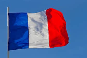 France flag is waving in front of blue sky