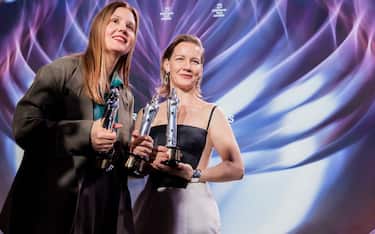 09 December 2023, Berlin: Sandra Hüller (r), winner of the "European Actress" category, and Justine Triet, winner of the "European Director" and "European Screenwriter" categories, stand on stage with their awards at the end of the European Film Awards ceremony. The European Film Academy (EFA) presents the awards at a gala in the Arena Berlin. Photo: Christoph Soeder/dpa (Photo by Christoph Soeder/picture alliance via Getty Images)
