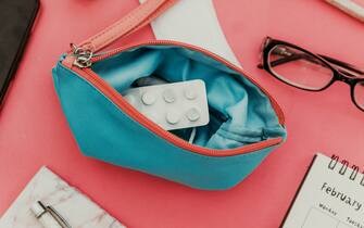 Menstrual tampons and pads in cosmetic bag. Menstruation time. Hygiene and protection