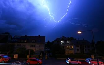 16 August 2023, Hesse, Frankfurt/Main: Lightning discharges in the evening sky during a heavy thunderstorm over the houses in the district of Sachsenhausen (shot with slow shutter speed). Photo: Arne Dedert/dpa (Photo by Arne Dedert/picture alliance via Getty Images)