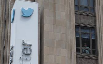 epa10766829 An employee peers out of a window near the iconic vertical Twitter sign at the company’s headquarters after work was halted on the altering of the sign in San Francisco, California, USA, 24 July 2023. The sign was being altered after Twitter owner Elon Musk annouced the rebranding of the social media platorm to X. San Francisco police responded to a call from building security that the signs were being stolen however a San Francisco police spokesperson stated that Twitter had a work order to take the sign down but didn’t communicate that to security and the property owner of the building.  EPA/JOHN G. MABANGLO