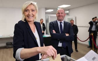 President of the ‘Rassemblement National’ (RN) group at the National Assembly Marine Le Pen (L), flanked by Steeve Briois (R), mayor of Henin Beaumont, casts her ballot for the European Parliament election at a polling station in Henin-Beaumont, north of France on June 9, 2024. Voting began across Europe on June 9, 2024 on the final -- and biggest -- day of marathon EU elections, with balloting due in 21 countries, including France and Germany, where support for surging far-right parties is being tested. (Photo by FRANCOIS LO PRESTI / AFP)