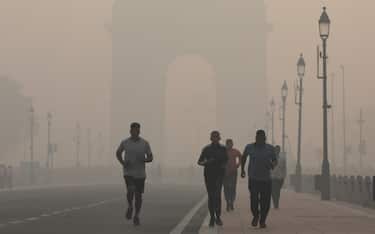epa10283274 People jog as the city is engulfed in heavy smog at Rajpath, in New Delhi, India, 03 November 2022. Delhi and National Capital Region's air quality slipped into the 'Severe and Hazardous' category as a result of stubble burning.  EPA/RAJAT GUPTA