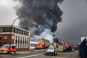 epa10566211 Firefighters try to extinguish a fire burning at a warehouse in the Rothenburgsort district of Hamburg, Germany, 09 April 2023. Residents have been warned of heavy smoke and possible toxins in the air. An alert issued by the Hamburg fire department said smoke gasses and chemical components in the air could affect breathing.  EPA/DOMINICK WALDECK