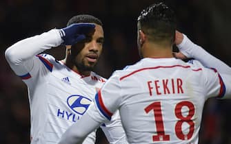 Lyon's French forward Alexandre Lacazette (L) celebrates with forward Nabil Fekir after scoring a penalty during the French L1 football match Olympique Lyonnais (OL) vs Caen (SMC) on December 12, 2014, at the Gerland Stadium in Lyon, central-eastern France. AFP PHOTO / JEFF PACHOUD        (Photo credit should read JEFF PACHOUD/AFP via Getty Images)