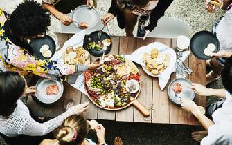 Overhead view of group of friends enjoy buffet of food during party