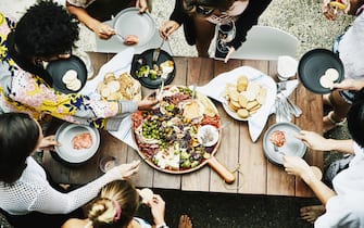 Overhead view of group of friends enjoy buffet of food during party