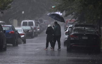 epa10890584 Pedestrians negotiate wet roads during heavy rain that caused widespread flooding in the Queens borough of New York, New York, USA, 29 September 2023.  EPA/JUSTIN LANE