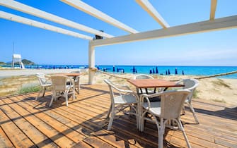 Beach restaurant in Cala Sinzias on sunny summer day, Sardinia island, Italy