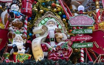 Colorful and intense christmas ornaments in athens streets. Santa and Elf. Santa is reading gift wishes.