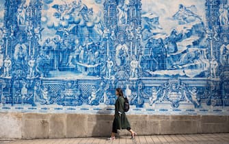 PORTO, PORTUGAL: Young woman passes azulejos Portuguese blue and white wall tiles of Capela das Almas de Santa Catarina  - St Catherine's Chapel in Porto, Portugal.  (Photo by Tim Graham/Getty Images)