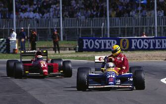 SILVERSTONE, UNITED KINGDOM - JULY 14: Ayrton Senna gets a lift back to the pits with Nigel Mansell, Williams FW14 Renault, ahead of Alain Prost, Ferrari 643 during the British GP at Silverstone on July 14, 1991 in Silverstone, United Kingdom. (Photo by Rainer Schlegelmilch)