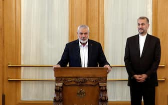 epa11244407 Hamas leader Ismail Haniyeh (L) speaks to the media as Iranian Foreign Minister Hossein Amir Abdoulhian (R) looks on, in Tehran, Iran, 26 March 2024. Haniyeh is in Tehran to meet with Iranian officials.  EPA/ABEDIN TAHERKENAREH