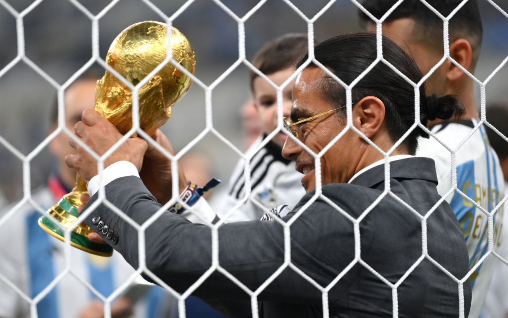 LUSAIL CITY, QATAR - DECEMBER 18: Nusret Goekce, nicknamed Salt Bae, admires the FIFA World Cup Qatar 2022 Winner's Trophy after the FIFA World Cup Qatar 2022 Final match between Argentina and France at Lusail Stadium on December 18, 2022 in Lusail City, Qatar. (Photo by Dan Mullan/Getty Images)