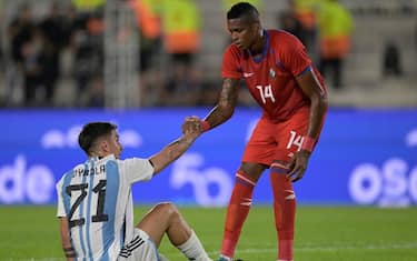 Panama's defender Gilberto Hernandez (R) helps Argentina's forward Paulo Dybala stand up during the friendly football match between Argentina and Panama at the Monumental stadium in Buenos Aires on March 23, 2023. Hernandez was shot dead by unknown gunmen in the Panamanian Caribbean city of Colon on September 3, 2023, and a suspect was arrested, police informed on September 4. The 26-year-old defender died Sunday afternoon when he and six other people were gunned down by unknown assailants in a car in a city where crime rates have risen due to apparent disputes between drug gangs. (Photo by Juan MABROMATA / AFP) (Photo by JUAN MABROMATA/AFP via Getty Images)