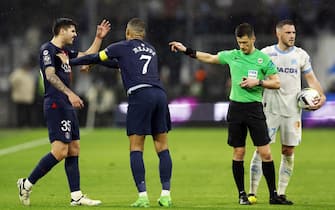 epa11253802 Kylian Mbappe (2L) of PSG calms his teammate Lucas Beraldo (L) down as he is sent off by referee Benoit Bastien (2-R) during the French Ligue 1 soccer match between Olympique Marseille and Paris Saint-Germain, in Marseille, France, 31 March 2024.  EPA/Guillaume Horcajuelo