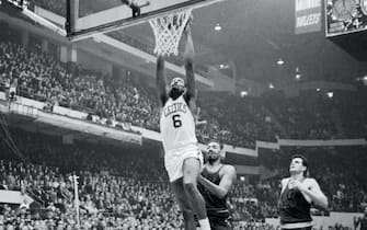 (Original Caption) Bill Russell soars high to dunk in two points, beating out 76ers' Wilt Chamberlain and Dave Gambee during fourth quarter action at the Boston Gardens. Celtics won game, 133-111.