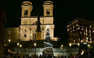TOPSHOT - A picture shows a christmas tree on the Spanish Steps at night with Trinita dei Monti church in the background, in Rome on December 2, 2025. (Photo by Tiziana FABI / AFP via Getty Images)