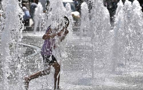 Bambini e turisti cercano refrigerio dalla calura africana, dalla fontana di piazza De Ferrari. Genova, 02 luglio 2025. 
ANSA/LUCA ZENNARO
