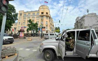 epa10709148 Servicemen from private military company (PMC) Wagner Group block a street leading to the Southern Military District headquarters building (back) in downtown Rostov-on-Don, southern Russia, 24 June 2023. Security and armoured vehicles were deployed after Wagner Group's chief Yevgeny Prigozhin said in a video that his troops had occupied the building of the headquarters of the Southern Military District, demanding a meeting with Russia s defense chiefs.  EPA/ARKADY BUDNITSKY