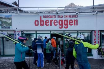 BOLZANO, ITALY - DECEMBER 12: People on the ski slopes about to take the cable car on December 12, 2021 in Obereggen, Italy. Ski facilities remained inactive for two years during the Covid-19 pandemic, re-opening in recent weeks with the hope of boosting tourism, yet with high infection rates and low vaccine turn-out the 2021 season remains uncertain. To combat the rise in Covid-19 cases in Italy, the government tightened health restrictions with a "super green pass" as of December 6.  (Photo by Francesca Volpi/Getty Images)