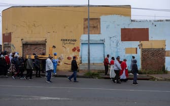 epa12038325 Members of the congregation of the St. Francis Xavier Martindale Church ca rry a cross as they walk the streets of the Westburg suburb marking Good Friday in Johannesburg, South Africa, 18 April 2025. Father PJ Cassidy and his congregation walked the streets of Westburg on Good Friday, praying for peace and sharing God s word in a suburb gripped by drugs, violence, and poverty.  EPA/KIM LUDBROOK