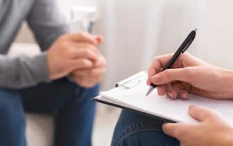 Psychologist taking notes during session with patient