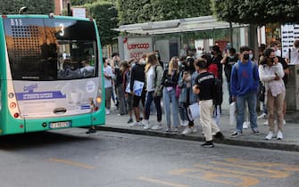 Gente alla fermata del bus a Brescia