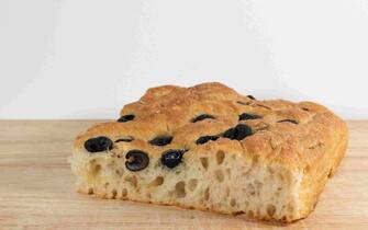 Original Italian focaccia genovese with black olives and rosemary. Traditional and delicious Italian salty food.