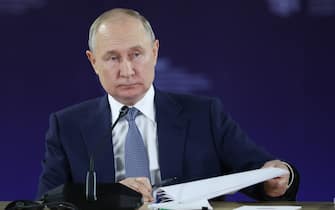 Il presidente della Russia Vladimir Putin mentre gira un foglio in occasione di un evento pubblico