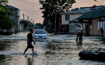 epa10676369 People walk in a flooded street of Kherson, Ukraine, 06 June 2023.Ukraine has accused Russian forces of destroying a critical dam and hydroelectric power plant on the Dnipro River in the Kherson region along the front line in southern Ukraine on 06 June. A number of settlements were completely or partially flooded, Kherson region governor Oleksandr Prokudin said on telegram. Russian troops entered Ukraine on 24 February 2022 starting a conflict that has provoked destruction and a humanitarian crisis.  EPA/IVAN ANTYPENKO