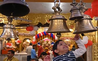 A child rings a bell during prayers on the occasion of Rama Navami festival, marking the birth anniversary of Hindu god Rama at a temple in New Delhi on March 30, 2023. (Photo by Arun SANKAR / AFP) (Photo by ARUN SANKAR/AFP via Getty Images)