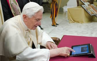 This handout picture released by the Vatican press office on December 12, 2012  shows Pope Benedict XVI sending his first twitter message during his weekly general audience at the Paul VI hall at the Vatican. Pope Benedict XVI sent his first Twitter message from a digital tablet on Wednesday using the handle @pontifex, blessing his hundreds of thousands of new Internet followers. AFP PHOTO / OSSERVATORE ROMANO/HO  RESTRICTED TO EDITORIAL USE - MANDATORY CREDIT "AFP PHOTO / OSSERVATORE ROMANO" - NO MARKETING NO ADVERTISING CAMPAIGNS - DISTRIBUTED AS A SERVICE TO CLIENTS (Photo by OSSERVATORE ROMANO / AFP) (Photo by -/OSSERVATORE ROMANO/AFP via Getty Images)