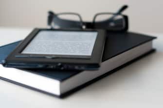 E-Reader and book with reading glasses.