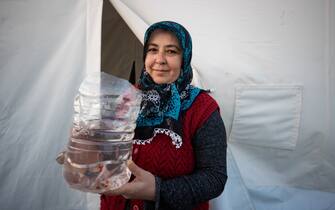 KAHRAMANMARAS, TURKIYE - FEBRUARY 24: Derya Akturk, an earthquake survivor lives the tent city established in Vali Saim Cotur Stadium and around with her fish named "Portal" after 7.7 and 7.6 magnitude earthquakes hit multiple provinces of Turkiye including Kahramanmaras on February 24, 2023. Some survivors of earthquakes in Kahramanmaras live together in a tent city with their animals, such as fish, birds, partridges, cats and dogs, which they rescued while leaving their homes. Established by the Sakarya 7th Commando Brigade Command, the tent city hosts nearly 3,500 earthquake victims as well as dozens of pets. (Photo by Fatih Kurt/Anadolu Agency via Getty Images)