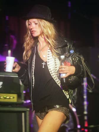 GLASTONBURY, ENGLAND - JUNE 25: Kate Moss walks across the Leftfield Stage on her way to watch her boyfriend Pete Doherty and his band Babyshambles perform, on the second day of the Glastonbury Music Festival 2005 at Worthy Farm, Pilton on June 25, 2005 in Somerset, England. The festival runs until June 26. (Photo by Matt Cardy/Getty Images)  *** Local Caption *** XXX

