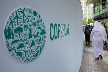 Participants walk past a COP28 sign at the Expo City during the United Nations climate summit in Dubai on December 3, 2023. (Photo by Giuseppe CACACE / AFP) (Photo by GIUSEPPE CACACE/AFP via Getty Images)