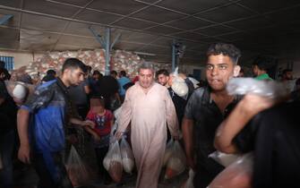 Palestinians storm a UN-run aid supply center, that distributes food to displaced families following Israel's call for more than one million residents in northern Gaza to move south for their safety, in Deir al-Balah on October 28, 2023, amid the ongoing battles between Israel and the Palestinian group Hamas. Thousands of civilians, both Palestinians and Israelis, have died since October 7, 2023, after Palestinian Hamas militants based in the Gaza Strip entered southern Israel in an unprecedented attack triggering a war declared by Israel on Hamas with retaliatory bombings on Gaza. (Photo by MOHAMMED ABED / AFP) / "The erroneous mention[s] appearing in the metadata of this photo by MOHAMMED ABED has been modified in AFP systems in the following manner: [Storm] instead of [Collect boxes and and bags from]. Please immediately remove the erroneous mention[s] from all your online services and delete it (them) from your servers. If you have been authorized by AFP to distribute it (them) to third parties, please ensure that the same actions are carried out by them. Failure to promptly comply with these instructions will entail liability on your part for any continued or post notification usage. Therefore we thank you very much for all your attention and prompt action. We are sorry for the inconvenience this notification may cause and remain at your disposal for any further information you may require." (Photo by MOHAMMED ABED/AFP via Getty Images)