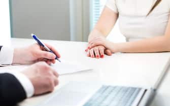 Young woman in job interview with business man. Interviewer writing notes. Lady having meeting with boss or executive manager.