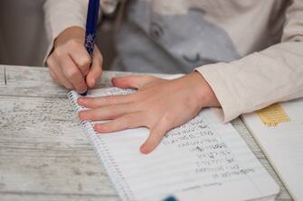 boy writing letter at the table at home