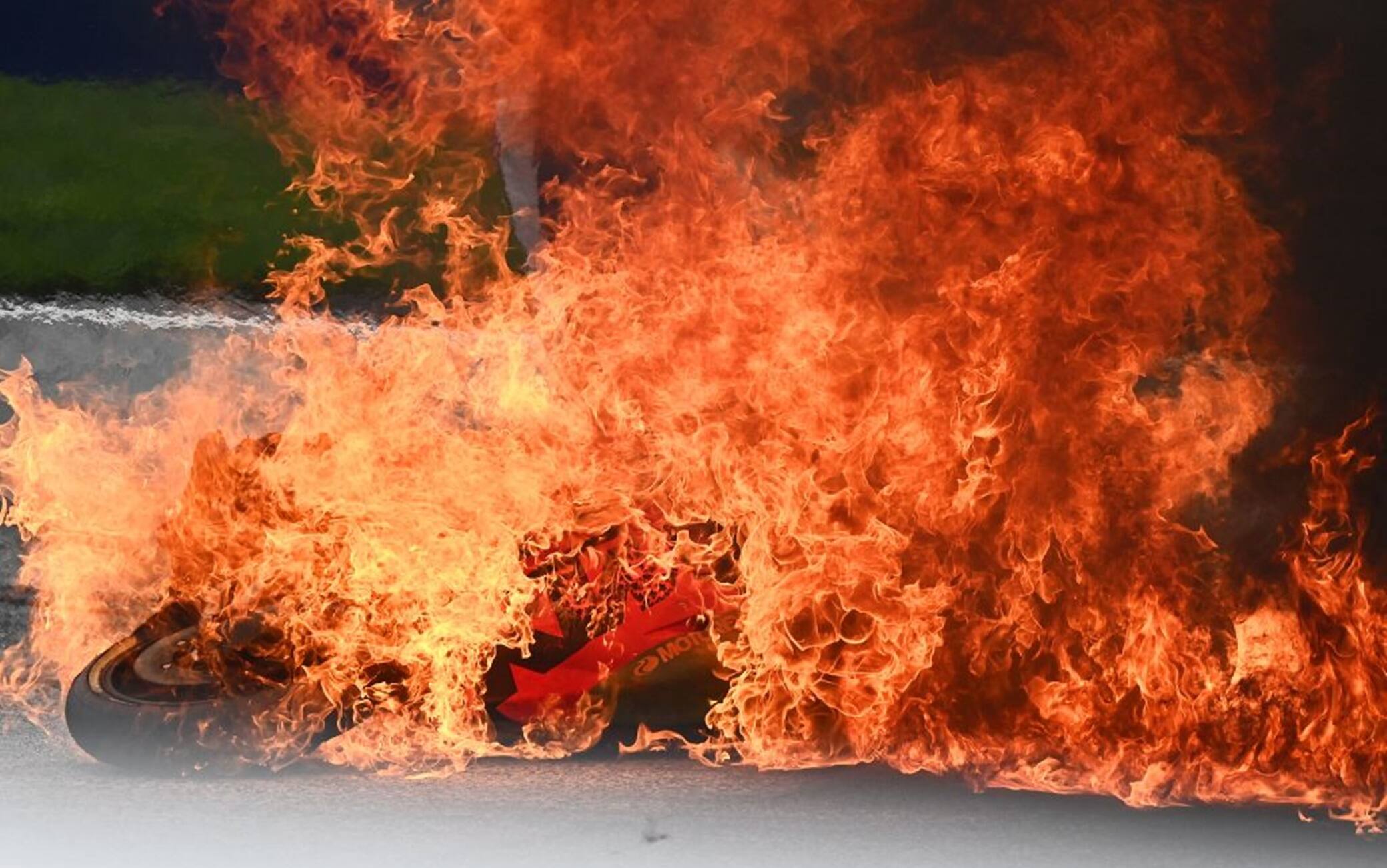 L'Aprilia di Savadori in fiamme dopo l'incidente con Pedrosa