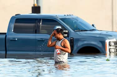 epa11467566 A man cools off while navigating flood waters following heavy rain from Hurricane Beryl in Houston, Texas, USA, 08 July 2024. The storm, which already caused widespread damage last week in the Caribbean, was downgraded to a tropical storm as it passed over the Gulf of Mexico before regaining strength into a hurricane.  EPA/CARLOS RAMIREZ