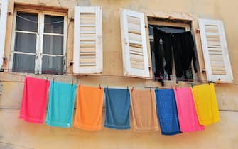 Two open windows with hanging colorful towels