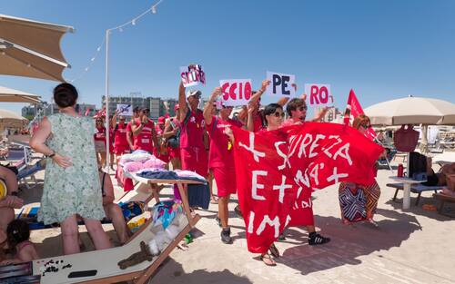 Sciopero simbolico dei bagnini oggi lungo il litorale della provincia di Rimini, dove i lavoratori del servizio di salvataggio hanno protestato per chiedere condizioni lavorative più eque. Al centro della mobilitazione, la richiesta di turni più sostenibili, nuove assunzioni e un servizio di salvataggio strutturato in maniera più sicura ed efficiente.

La protesta, indetta nel pieno della stagione estiva, non ha comportato interruzioni del servizio: grazie alla precettazione disposta dalla Prefettura, i bagnini hanno comunque garantito la sorveglianza in torretta, mentre la manifestazione si è svolta in forma ordinata.

Il corteo è partito intorno alle 12.30 dalla zona dei bagni 36-37 di Rimini, snodandosi lungo il litorale fino a raggiungere il piazzale Boscovich. Nessun disagio segnalato per i turisti presenti in spiaggia. Rimini, 9 agosto 2025. ANSA/Ph Dorin Mihai, Pasquale Bove

____

EN:

Italy: Rimini lifeguards hold symbolic strike, no impact on beach safety. Prefect orders mandatory service

RIMINI, Italy, Aug 9 (ANSA) – Lifeguards along Rimini’s coastline staged a symbolic strike on Saturday to protest working conditions during the peak summer season. The workers are demanding more manageable shift schedules, additional personnel, and improved safety protocols for rescue operations.

Despite the strike announcement, no disruption to beach safety was reported. Under an order issued by the Prefect, lifeguards were required to remain at their posts, ensuring continuous coverage of the shoreline.

The demonstration, which unfolded without incident, included a peaceful march beginning at 12:30 p.m. near Rimini bathing areas 36–37 and proceeding along the seafront to Piazzale Boscovich. Tourists and beachgoers were largely unaffected. Rimini (Italy) august 9 2025, ANSA/Ph Dorin Mihai, Pasquale Bove