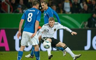 Il centrocampista della nazionale tedesca, Bastian Schweinsteiger (D), contrastato dai giocatori italiani Thiago Motta (S) e Giorgio Chiellini durante la partita amichevole allo stadio di Dortmund, in una immagine del 09 febbraio 2011.
ANSA/BERND THISSEN