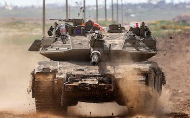 This picture taken from Israel's southern border with the Gaza Strip shows Israeli army battle tank moving at a position along the border with the Palestinian territory on March 19, 2024, amid the ongoing conflict between Israel and the militant group Hamas. (Photo by JACK GUEZ / AFP)
