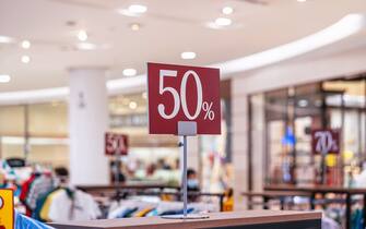 Discount 50% label of sales tag price over the clothes line in the shopping department store for shopping.