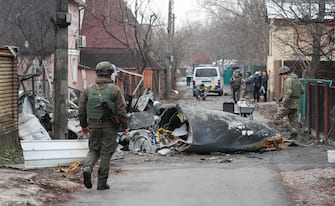 Giorno 2 Kiev sotto attacco - epa09783634 Soldiers look at the debris of a military plane that was shot down overnight in Kiev, Ukraine, 25 February 2022. Russian troops entered Ukraine on 24 February prompting the country's president to declare martial law.  EPA/SERGEY DOLZHENKO